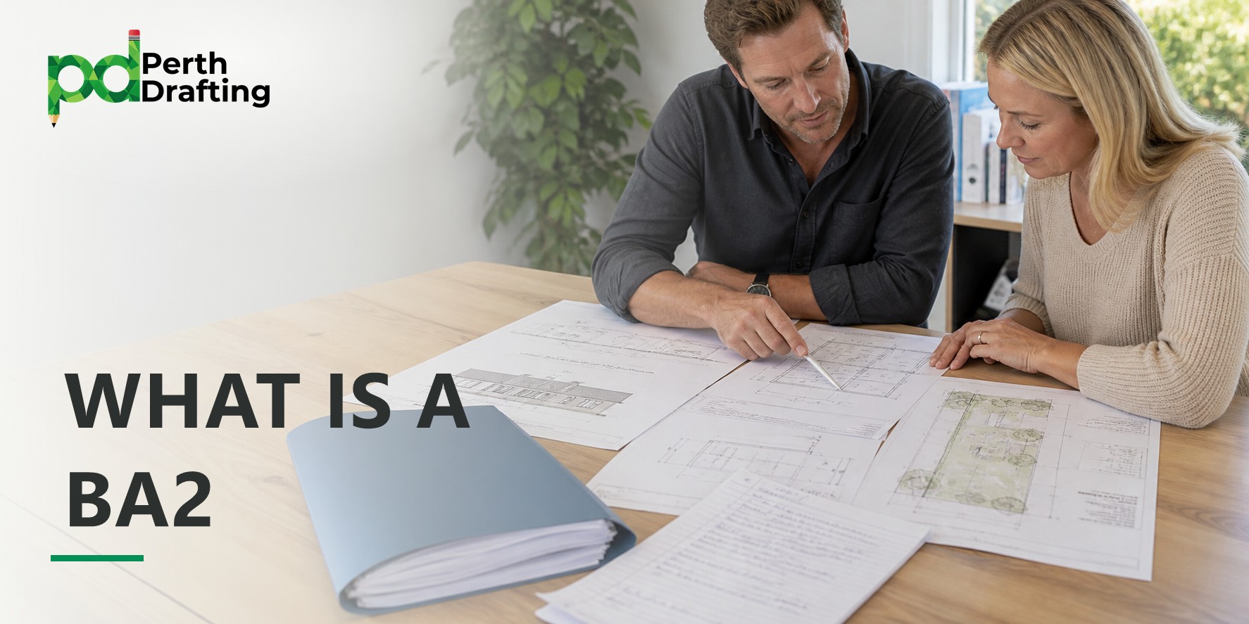A man and a woman sitting at a wooden table, looking over large architectural plans. The man is pointing at a detail on the plans with a pen. A light-blue folder and handwritten document pages are sitting on the desk next to them.