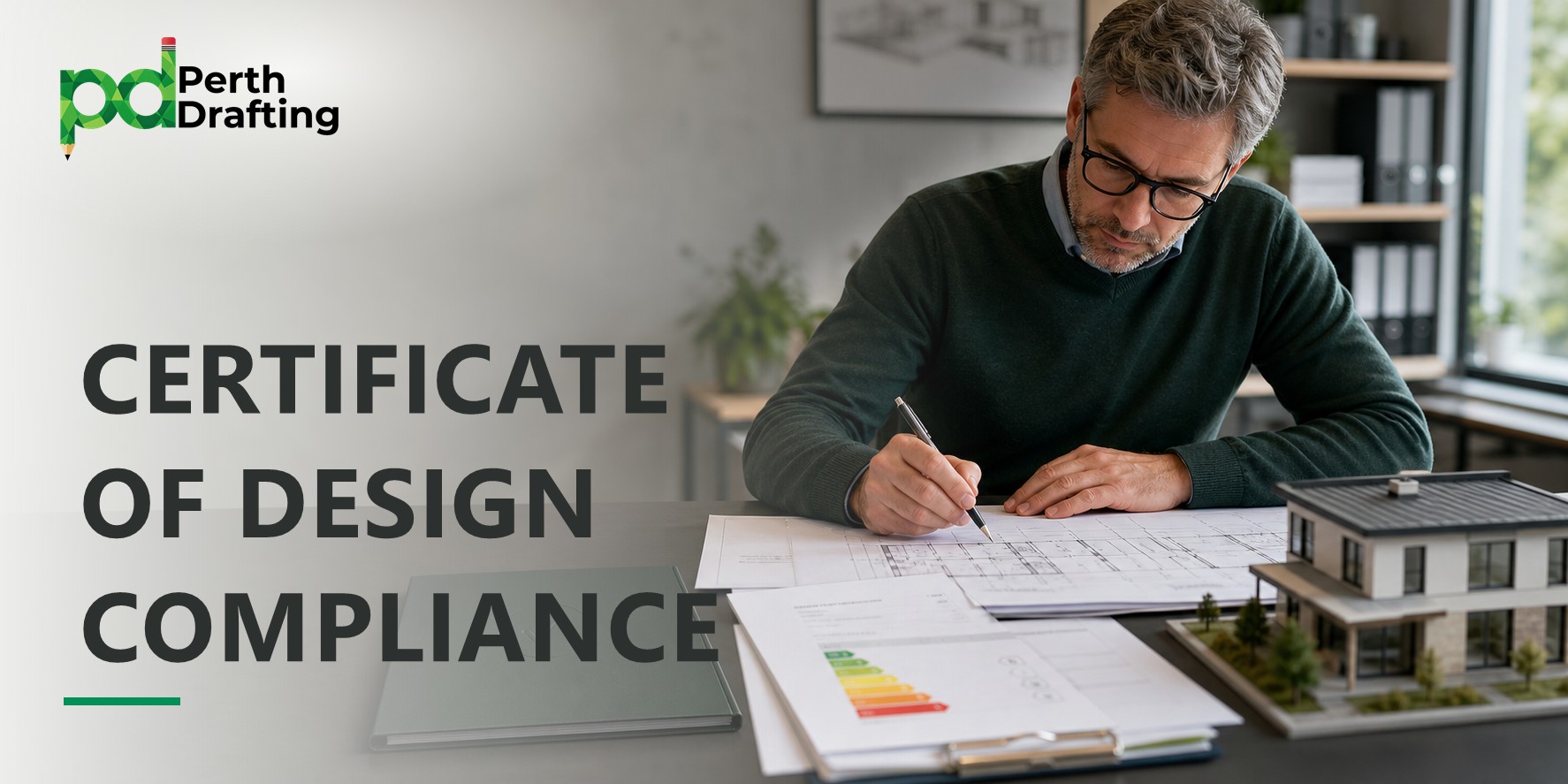 A man with glasses wearing a dark sweater sitting at a desk, writing on architectural floor plans. On his desk are a clipboard with an energy rating report, a folder, and a small 3D scale model of a modern two-story home.